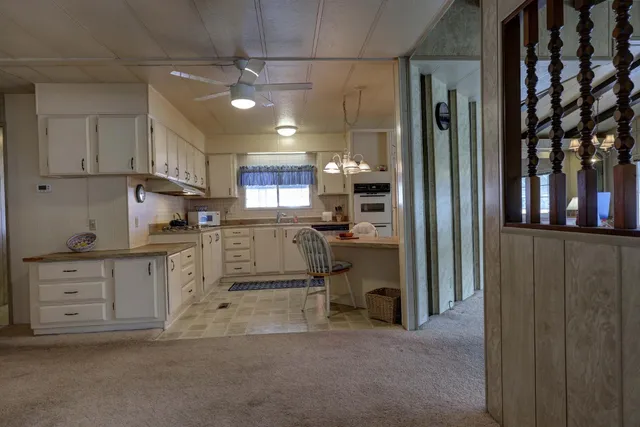 a kitchen with white cabinets and refrigerator
