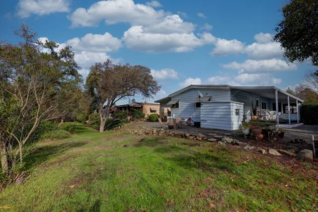 a backyard of a house with table and chairs