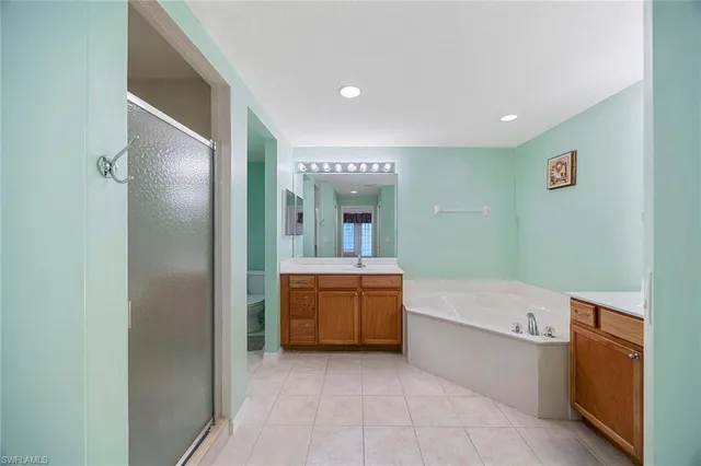 a bathroom with a tub sink and mirror
