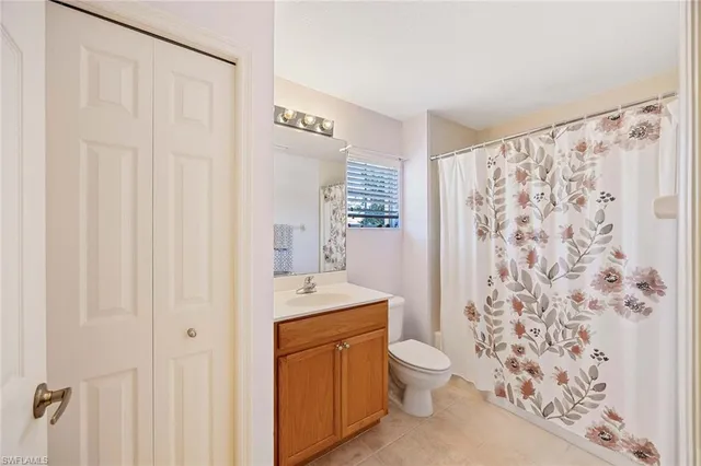 a bathroom with a toilet a sink and a shower curtain