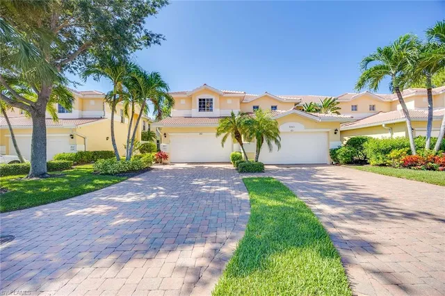 a front view of a house with a yard and a garage