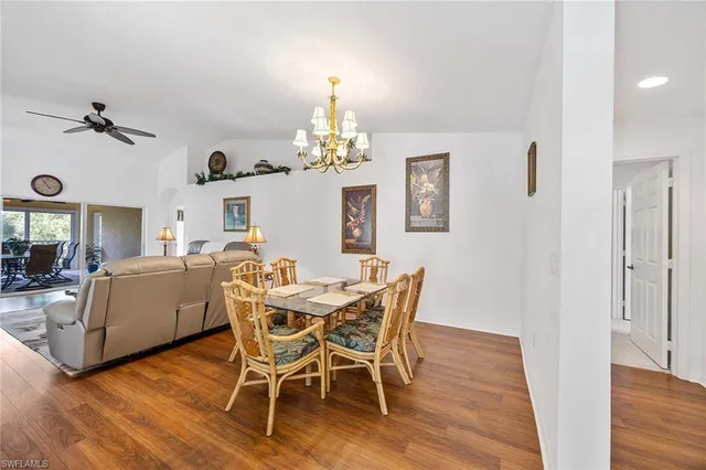 a dining room with furniture a chandelier and wooden floor