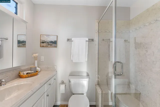 a bathroom with a granite countertop sink mirror and toilet