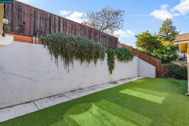 a view of a house with a yard and wooden fence
