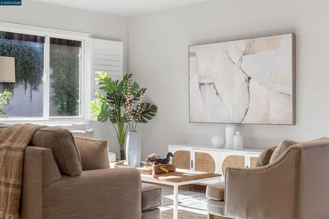 a living room with furniture and a dining table with wooden floor