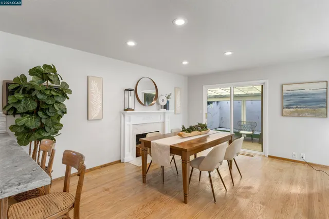 a view of a dining room with furniture a fireplace and wooden floor