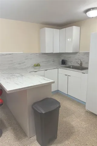 a kitchen with a sink cabinets and stove top oven