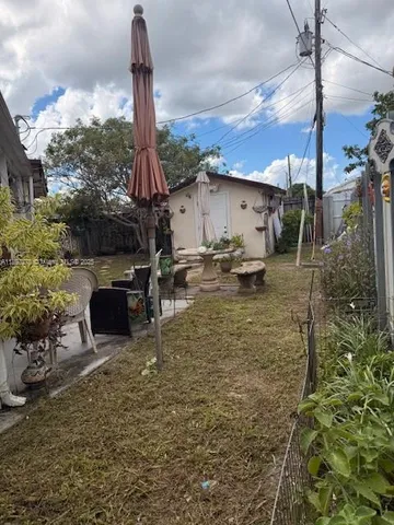 a backyard of a house with table and chairs