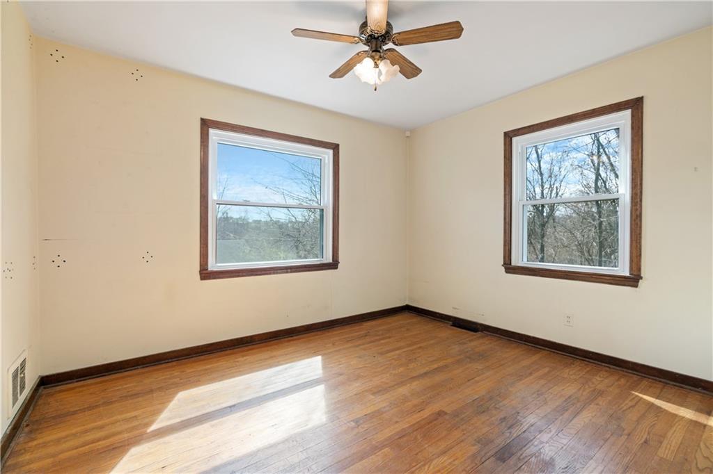 801 Maple Way Oakmont, PA 15139 - Photo 20 of 23 a view of an empty room with a window and wooden floor