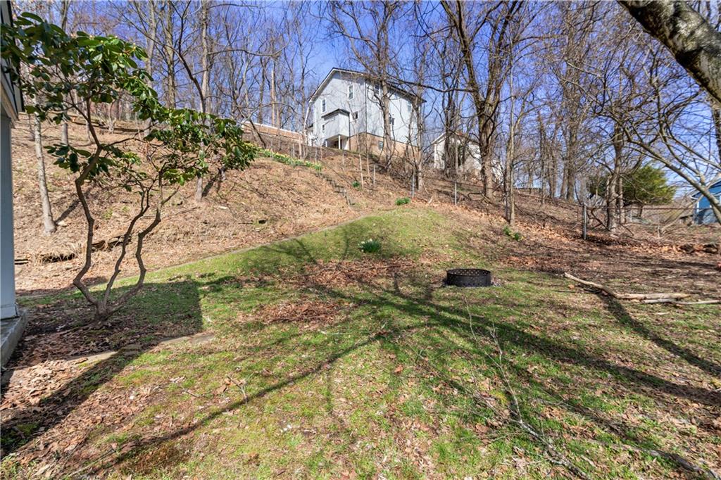 801 Maple Way Oakmont, PA 15139 - Photo 5 of 23 a view of a yard with yellow flowers and wooden fence