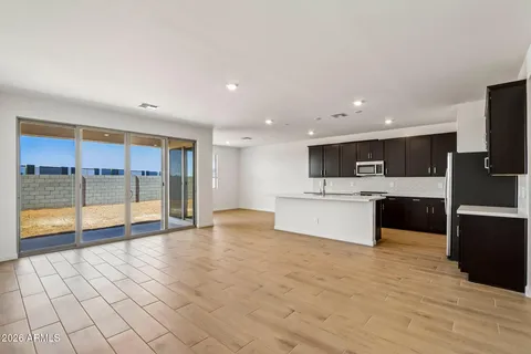 a large kitchen with stainless steel appliances kitchen island granite countertop a stove top oven a sink and dishwasher a refrigerator with wooden floor