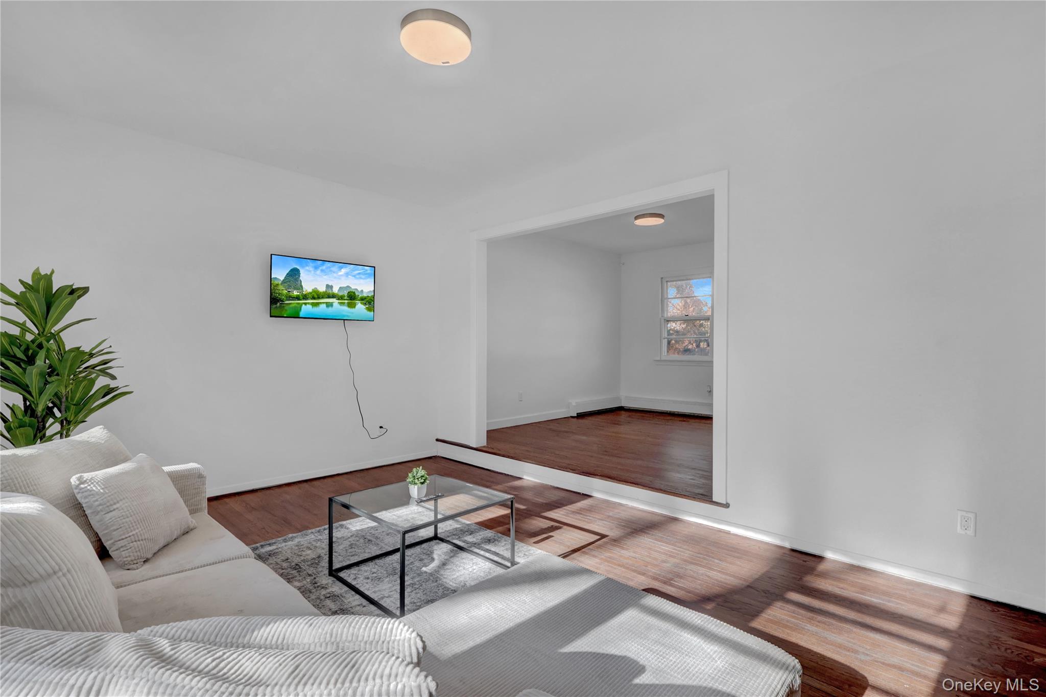 57 Middle Island Road Medford, NY 11763 - Photo 8 of 27 Living area with wood finished floors and a baseboard radiator