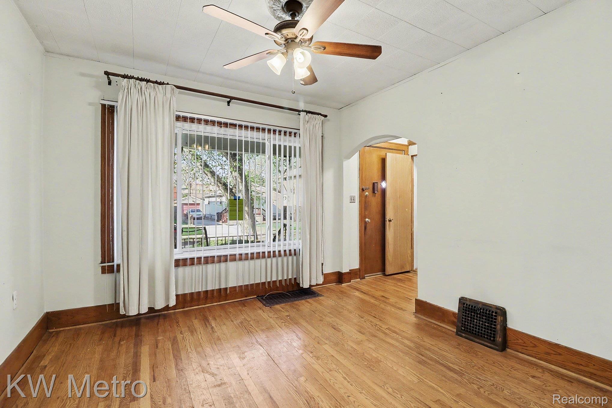 Spare room with light wood-style floors, arched walkways, and ceiling fan