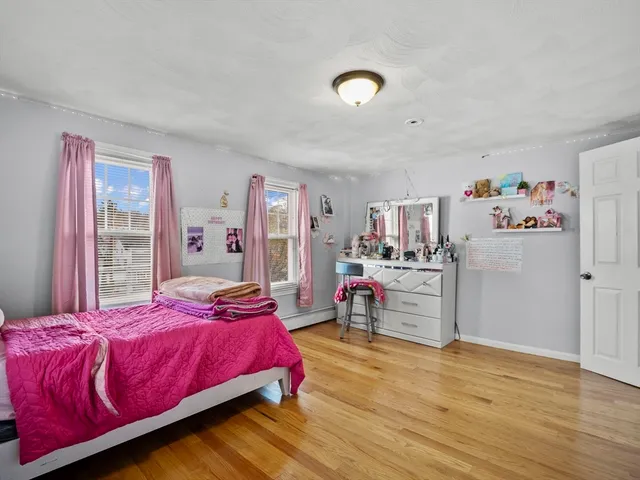 a bedroom with a bed and a refrigerator