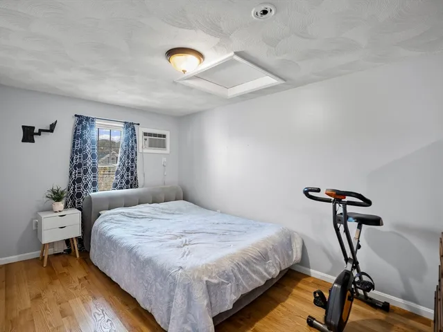 a bedroom with a bed a window and gym cycle