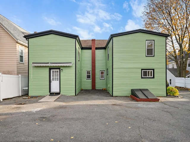 a view of a house with barbeque and wooden fence