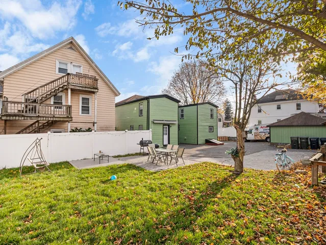 a view of a house with backyard and sitting area