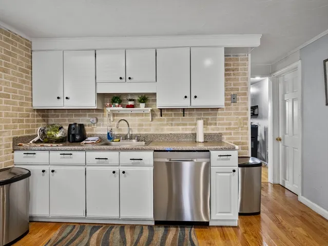 a kitchen with white cabinets stainless steel appliances and sink