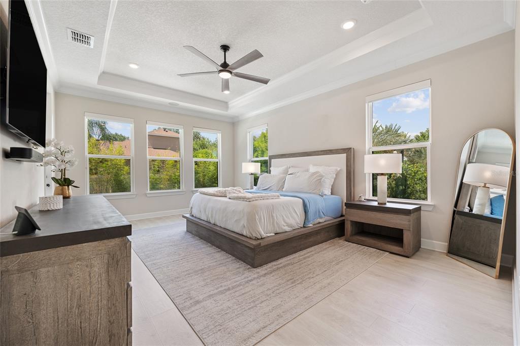 10175 Brocksport Circle Gotha, FL 34734 - Photo 17 of 54 a bedroom with a large bed and a flat tv screen
