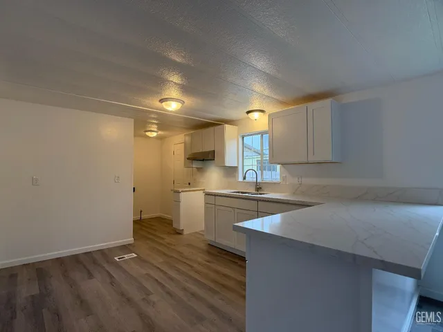 a kitchen with a sink cabinets stainless steel appliances and a counter top space