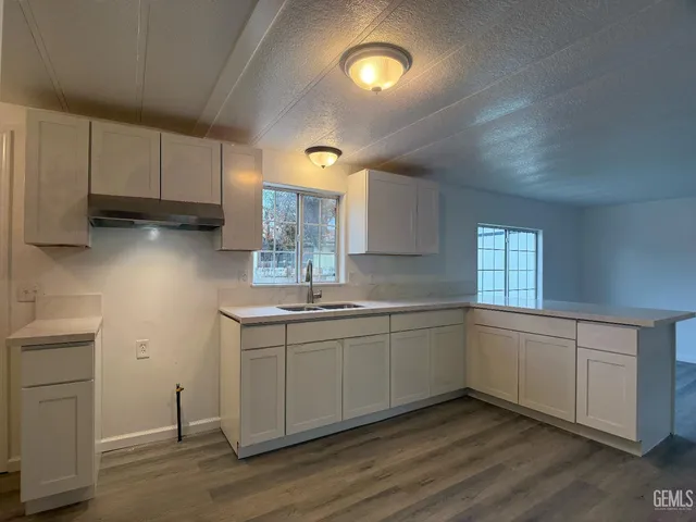 a kitchen with sink cabinets and wooden floor
