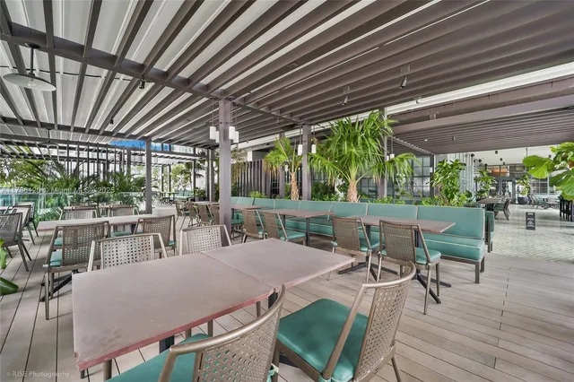 a patio with a table and chairs with wooden floor
