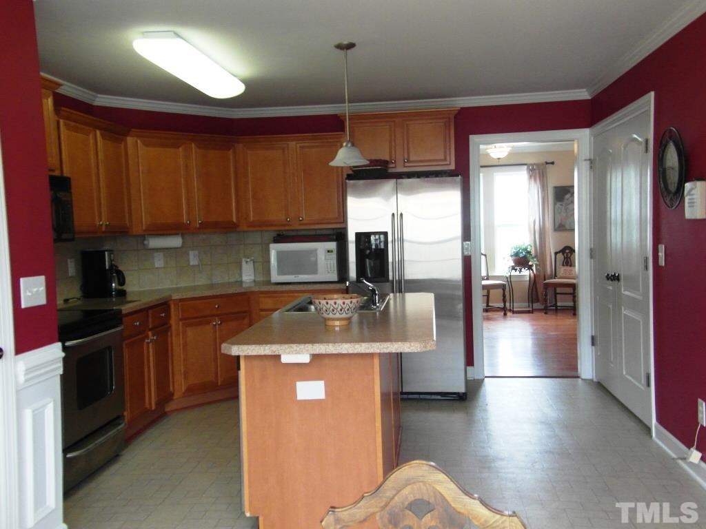 4936 Contender Drive Raleigh, NC 27603 - Photo 11 of 25 a kitchen with stainless steel appliances granite countertop a sink stove and refrigerator