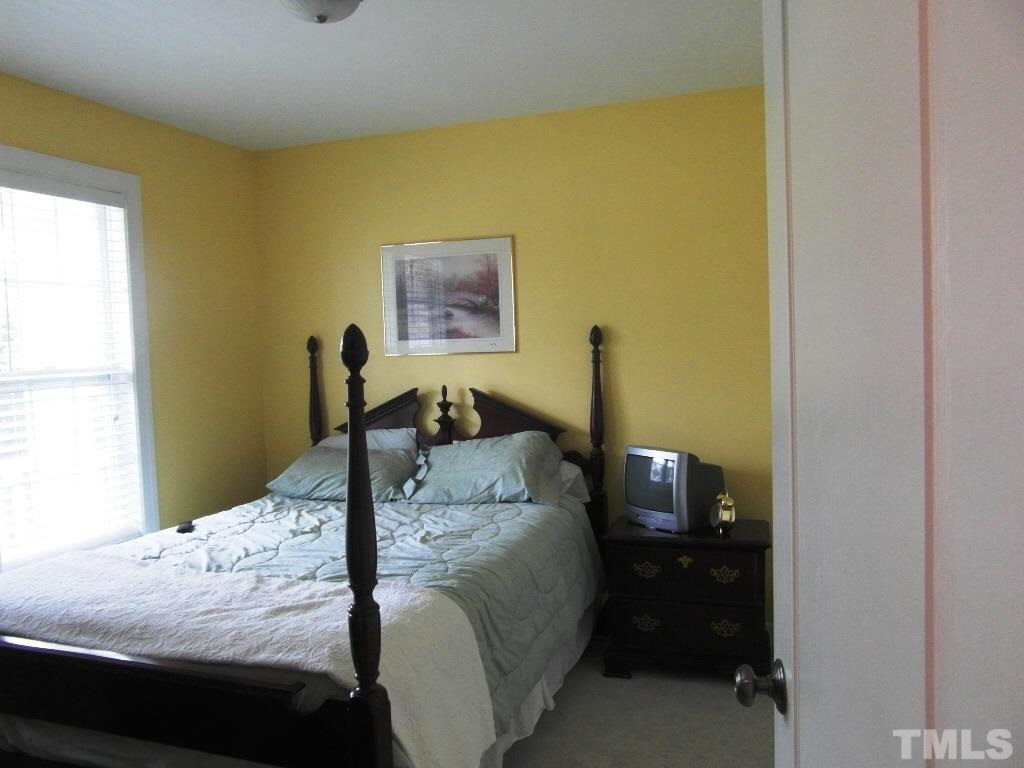 4936 Contender Drive Raleigh, NC 27603 - Photo 13 of 25 a bedroom with a bed and a window