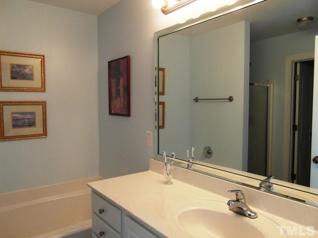 4936 Contender Drive Raleigh, NC 27603 - Photo 14 of 25 a bathroom with a sink and a mirror