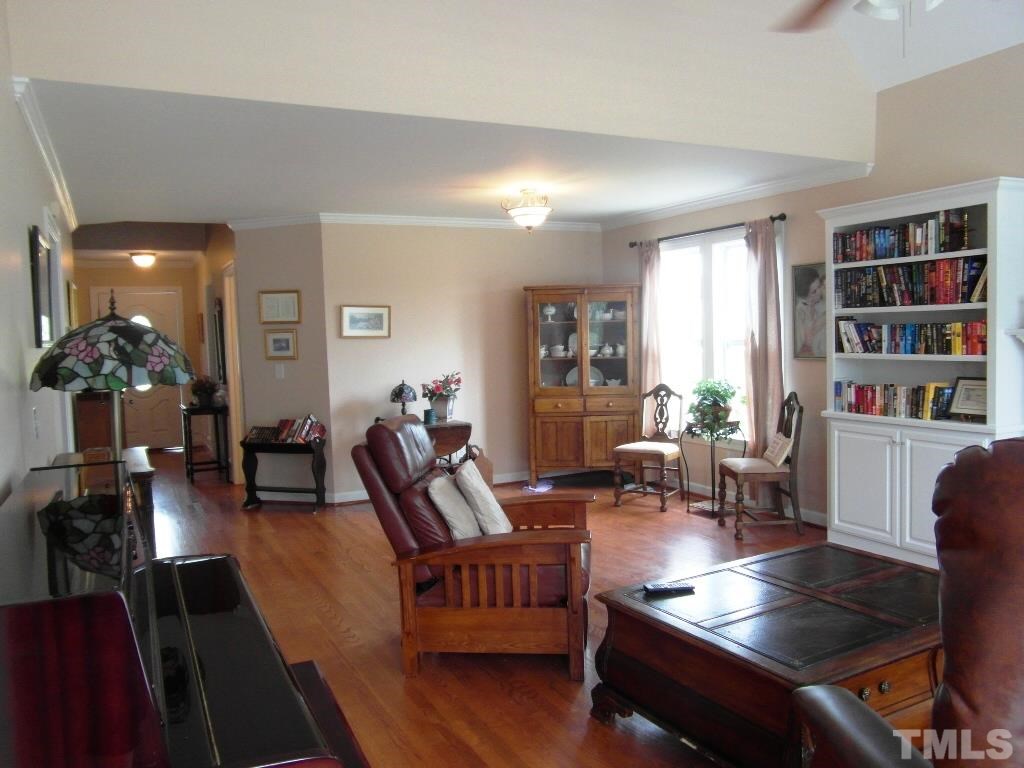 4936 Contender Drive Raleigh, NC 27603 - Photo 6 of 25 a living room with furniture and a book shelf