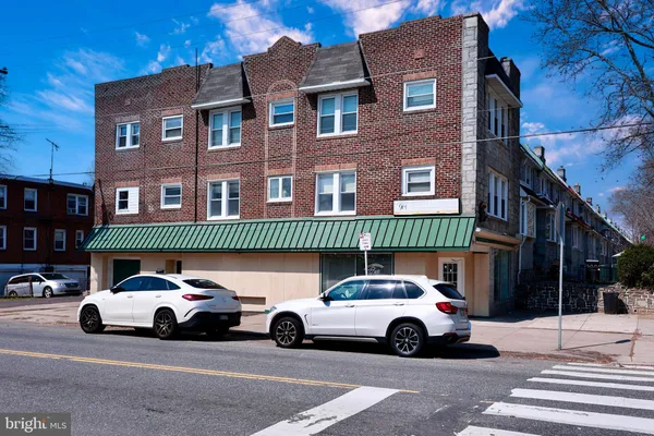 a view of parking with cars parked in front of a house