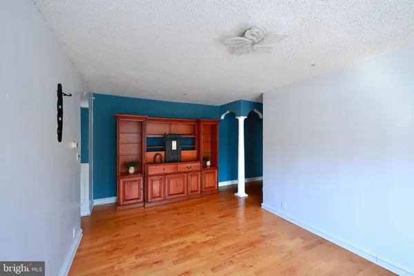 an empty room with large window and a ceiling fan