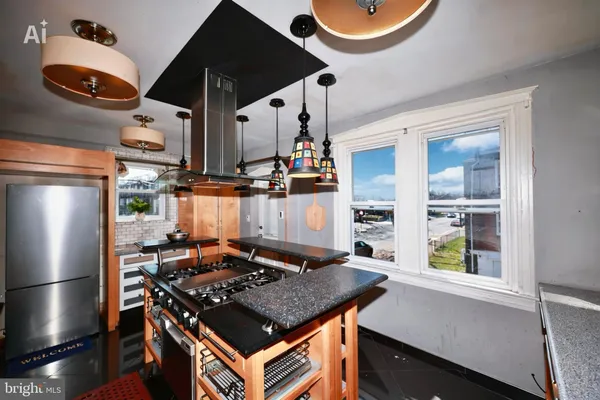 a kitchen with stainless steel appliances granite countertop a stove a refrigerator and a dining table
