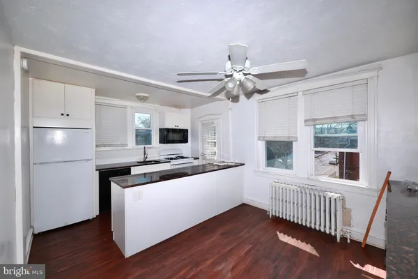 a kitchen with stainless steel appliances a white stove top oven and a window