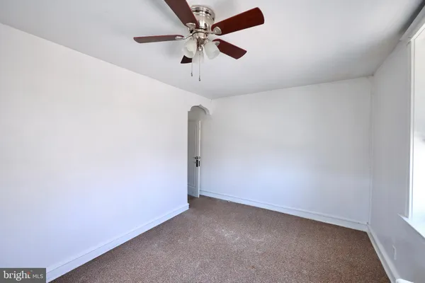 an empty room with a ceiling fan and a window