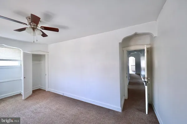 a view of a room with a ceiling fan and closet