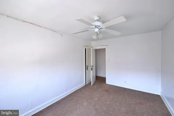 an empty room with a ceiling fan and a window