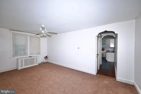 a view of empty room with cabinet and mirrors