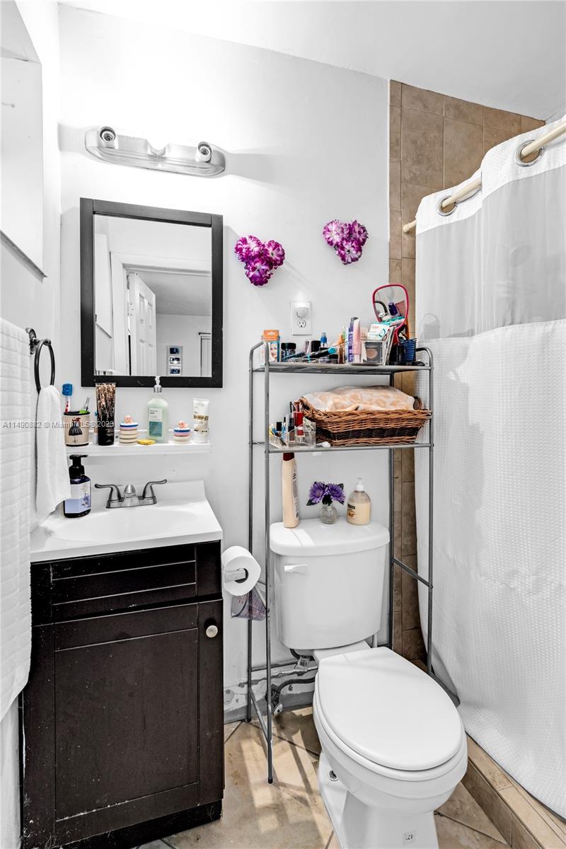 3551 Frow Avenue Miami, FL 33133 - Photo 15 of 22 a bathroom with a sink a toilet and a mirror