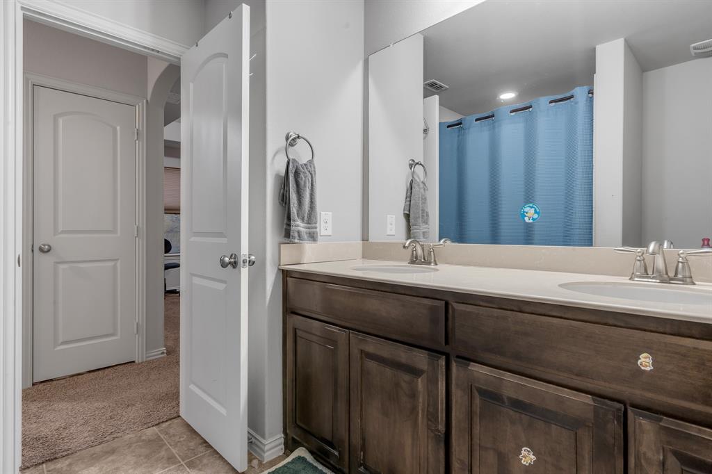 1229 Harris Hawk Way Arlington, TX 76005 - Photo 22 of 40 a bathroom with a double vanity sink and a mirror