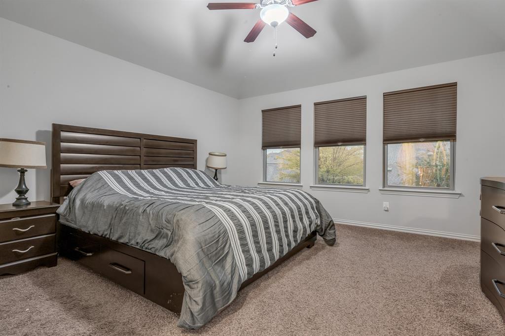 1229 Harris Hawk Way Arlington, TX 76005 - Photo 24 of 40 a bed sitting in a bedroom next to a window