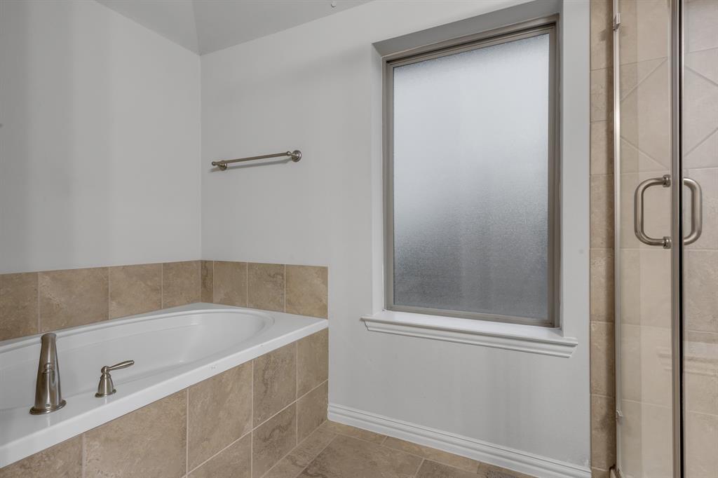 1229 Harris Hawk Way Arlington, TX 76005 - Photo 26 of 40 a bathroom with a tub and shower