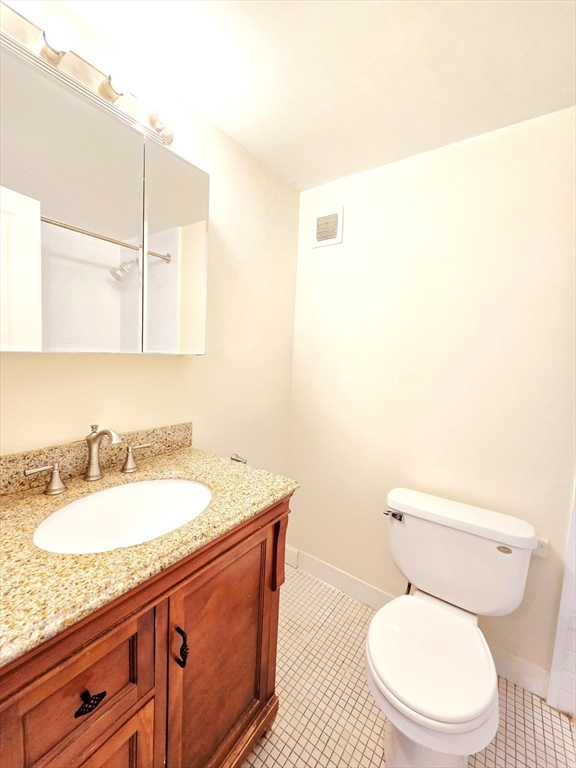 200 Swanton Street, Unit 318 Winchester, MA 01890 - Photo 5 of 9 a bathroom with a granite countertop toilet sink and mirror