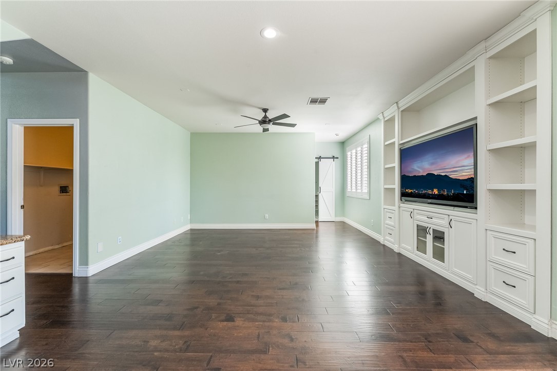 261 Timber Hollow Street Henderson, NV 89012 - Photo 12 of 51 Built-in shelving and media center creates a streamlined aesthetic in this spacious room with rich hardwood flooring.