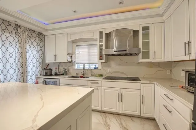 a kitchen with stainless steel appliances granite countertop a sink and cabinets with wooden floor