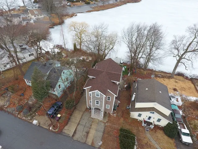 an aerial view of a house with a yard garage and lake view