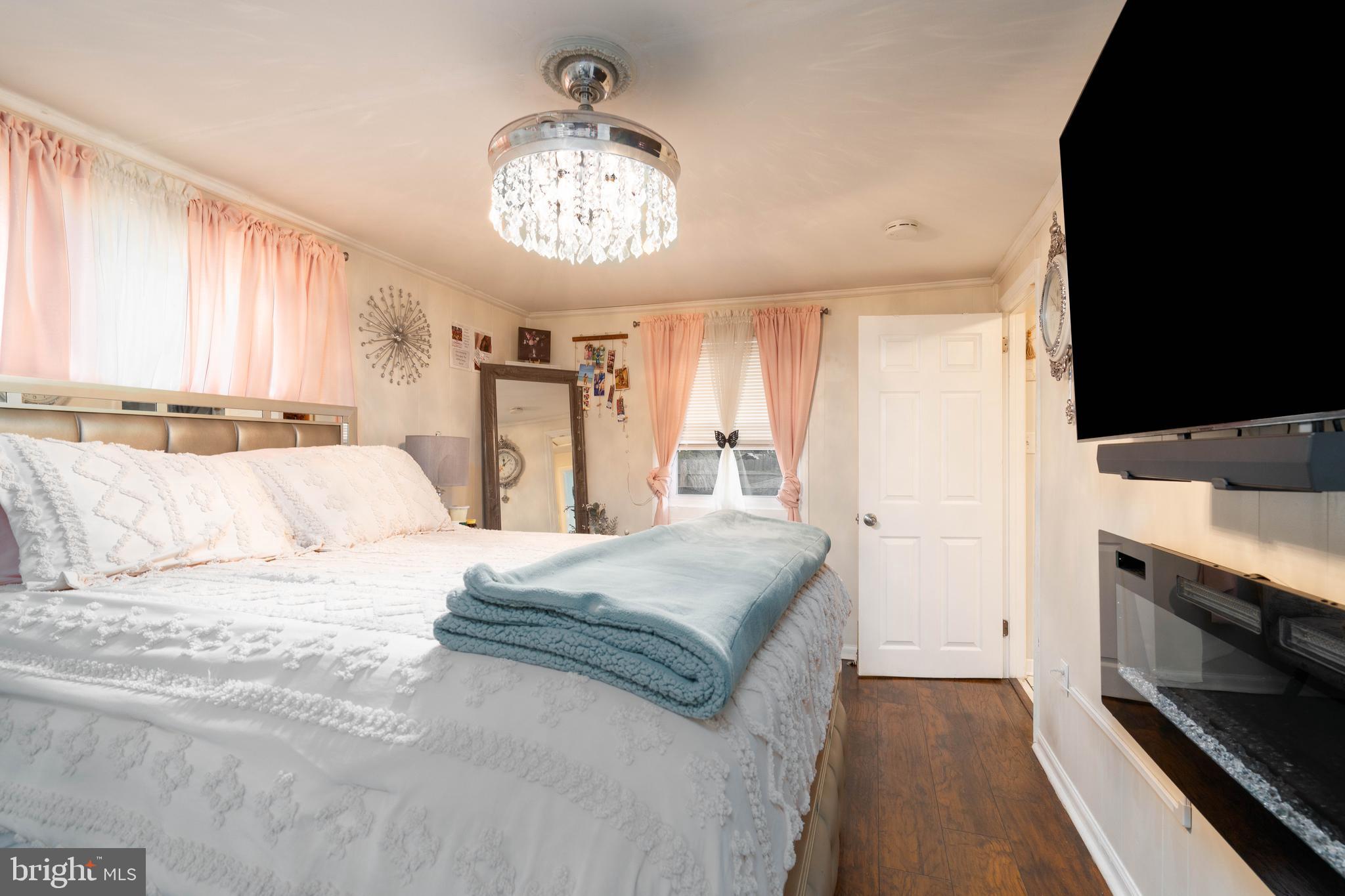 519 Clarendon Avenue Vineland, NJ 08360 - Photo 11 of 22 a spacious bedroom with a bed and a chandelier