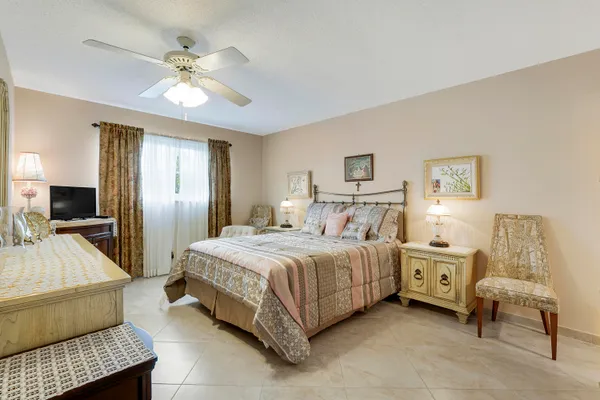 a spacious bedroom with a bed and a chandelier