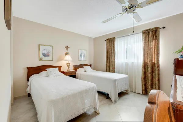 a spacious bedroom with two beds and a chandelier