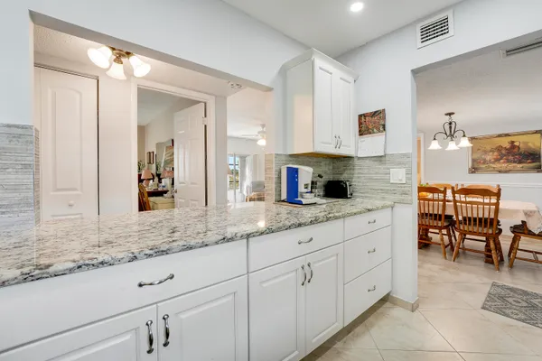 a kitchen with granite countertop white cabinets and sink